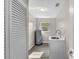 Clean laundry room featuring a utility sink, gray wood-look flooring, and a water heater near a window at 824 35Th Avenue W Dr, Palmetto, FL 34221