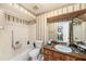 Bathroom with tub, toilet, vanity, and mirrored cabinet at 8305 Palencia Dr, Port Richey, FL 34668