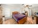 This bedroom features a ceiling fan, wood-look floors, a closet, and natural light at 8305 Palencia Dr, Port Richey, FL 34668