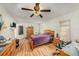 This bedroom features a ceiling fan, wood-look floors, a closet, and natural light at 8305 Palencia Dr, Port Richey, FL 34668