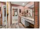 Stylish bathroom featuring a brick wall, granite countertops, and a view of the walk-in closet at 9114 Dorsey St, Spring Hill, FL 34608