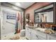 Nicely remodeled bathroom with white tiled shower, and brick accent wall and stylish vanity at 9114 Dorsey St, Spring Hill, FL 34608