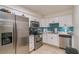 Updated kitchen with stainless steel appliances, white cabinets and blue glass tile backsplash at 9481 Highland Oak Dr # 710, Tampa, FL 33647