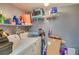 Functional laundry room with a washer, dryer, shelving, and storage space at 9481 Highland Oak Dr # 710, Tampa, FL 33647