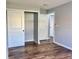 Bedroom featuring hardwood floors, closet, and adjacent doors to bathroom and other rooms at 9893 86Th N Way, Seminole, FL 33777