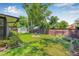 Green backyard features a wooden fence, storage shed, and a fire pit at 9981 58Th N St, Pinellas Park, FL 33782