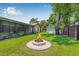 Well-maintained backyard with lush grass, storage shed, and brick-lined fire pit at 9981 58Th N St, Pinellas Park, FL 33782