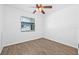 This light and airy bedroom features wood-look tile floors, a ceiling fan, and a window with blinds at 9981 58Th N St, Pinellas Park, FL 33782