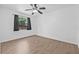 This bright and airy bedroom features wood-look tile floors, a ceiling fan, and a window with curtains at 9981 58Th N St, Pinellas Park, FL 33782