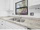 Close-up of the kitchen sink and granite countertop showcasing the decorative window and modern faucet at 9981 58Th N St, Pinellas Park, FL 33782