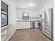 Bright kitchen features white cabinetry, stainless steel appliances, granite countertops, and wood-look tile flooring at 9981 58Th N St, Pinellas Park, FL 33782