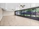 Enclosed sunroom features tile floors, ceiling fans, and large windows overlooking the landscaped backyard at 9981 58Th N St, Pinellas Park, FL 33782