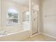 Bathroom featuring a soaking tub, glass enclosed shower, and tile flooring at 10150 Heather Sound Dr, Tampa, FL 33647