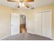 Bedroom features carpet and white closet doors; doorway leads to another room with hardwood floors at 10150 Heather Sound Dr, Tampa, FL 33647