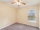 Cozy bedroom featuring neutral carpet, a ceiling fan and a window bringing in natural light at 10150 Heather Sound Dr, Tampa, FL 33647