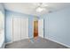 Bright bedroom featuring blue walls, neutral carpet, a closet and a view to the outside at 10150 Heather Sound Dr, Tampa, FL 33647