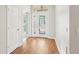 Bright foyer featuring wood flooring, a decorative glass front door with transom window, and white trim at 10150 Heather Sound Dr, Tampa, FL 33647