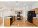 Functional kitchen featuring black appliances, wood cabinetry, and a breakfast bar overlooking the living area at 10150 Heather Sound Dr, Tampa, FL 33647