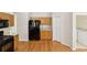 Kitchen featuring wooden cabinets, black appliances, and adjacent to the laundry room with washer and dryer hookups at 10150 Heather Sound Dr, Tampa, FL 33647