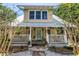Charming two-story home with a cozy front porch, a metal roof, and a blue front door at 1038 Crescent Lake N Dr, St Petersburg, FL 33701