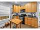 Functional kitchen featuring wood cabinets, black appliances, and a butcher block island for efficient meal prep at 1038 Crescent Lake N Dr, St Petersburg, FL 33701