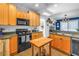 Bright kitchen with wood cabinets, black appliances, and seamless access to the dining and living spaces at 1038 Crescent Lake N Dr, St Petersburg, FL 33701