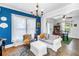 Cozy living room featuring a blue accent wall, large windows, and an adjoining dining area at 1038 Crescent Lake N Dr, St Petersburg, FL 33701
