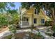 Charming two-story home with a side porch, a metal roof, and lush landscaping at 1038 Crescent Lake N Dr, St Petersburg, FL 33701