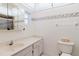 Bright bathroom with vanity, toilet, mirror, dolphin-themed border, and shower at 10430 42Nd N St, Clearwater, FL 33762