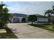 Charming home with arched entryway, well-maintained landscaping, and spacious driveway at 10430 42Nd N St, Clearwater, FL 33762