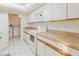 Bright kitchen featuring a skylight, white cabinets, and clean appliances at 10430 42Nd N St, Clearwater, FL 33762