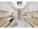 Bright kitchen featuring a skylight, white cabinets, and tile flooring at 10430 42Nd N St, Clearwater, FL 33762