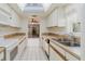 Bright kitchen view featuring a skylight, white cabinets, and stainless steel sink at 10430 42Nd N St, Clearwater, FL 33762