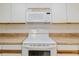 Clean kitchen area featuring a white stove and microwave, and ample counter space at 10430 42Nd N St, Clearwater, FL 33762