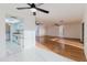 Open-concept living room with tile and wood flooring, featuring a ceiling fan and bright lighting at 10430 42Nd N St, Clearwater, FL 33762