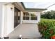 Outdoor patio area with sliding glass door access and a view of the blooming shrubbery at 10430 42Nd N St, Clearwater, FL 33762