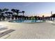 Community pool at dusk featuring ample seating, umbrellas, and lush palm trees for a relaxing environment at 10430 42Nd N St, Clearwater, FL 33762