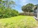 View of a backyard featuring a well-maintained lawn, wooden fence, and mature greenery at 106 E Cedar St, Tarpon Springs, FL 34689