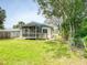 Backyard view of a home featuring a screened porch and well-maintained lawn at 106 E Cedar St, Tarpon Springs, FL 34689