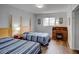 Bedroom features 2 beds with blue striped comforters, wood floors, and a wood desk at 106 E Cedar St, Tarpon Springs, FL 34689