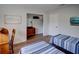 Bedroom features 2 beds with blue striped comforters, wood floors, and a wood dresser with a mirror at 106 E Cedar St, Tarpon Springs, FL 34689
