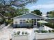 Inviting single story home featuring a beautiful front yard and quaint outdoor seating area at 106 E Cedar St, Tarpon Springs, FL 34689