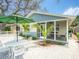 Charming home featuring a cozy front yard with a patio set under a green umbrella, perfect for outdoor relaxation at 106 E Cedar St, Tarpon Springs, FL 34689