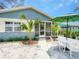 Charming home featuring a cozy front yard with a patio set under a green umbrella, perfect for outdoor relaxation at 106 E Cedar St, Tarpon Springs, FL 34689