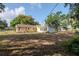 Backyard view of the house with a sunroom featuring large windows, and large trees at 108 E Morgan St, Brandon, FL 33510