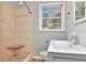 Bathroom featuring a tiled shower with built-in seat, modern vanity, and a window with natural light at 108 E Morgan St, Brandon, FL 33510