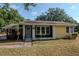 Inviting home with a covered front porch, black and yellow exterior, and well-maintained landscaping at 108 E Morgan St, Brandon, FL 33510