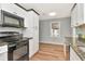 Kitchen featuring black appliances, granite counters, white cabinets, and wood-look floors at 108 E Morgan St, Brandon, FL 33510