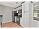 Kitchen featuring black appliances, white cabinets and wood-look floors at 108 E Morgan St, Brandon, FL 33510