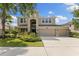 Charming two-story home featuring a manicured lawn, three-car garage, and covered entryway at 10837 Breaking Rocks Dr, Tampa, FL 33647